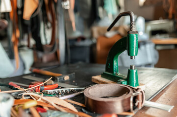 close-up puncher and others leather crafts tools on a desk.