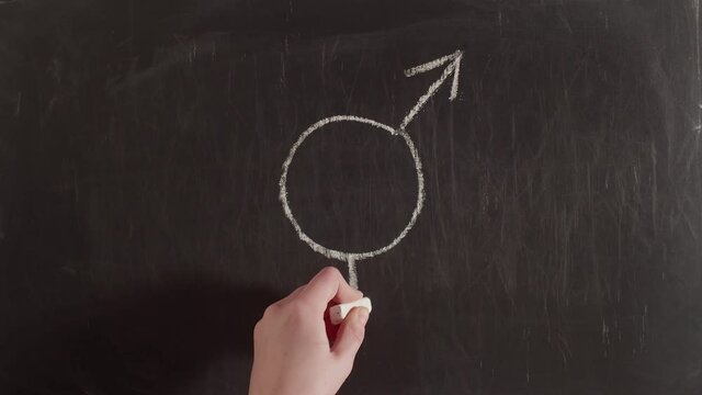 Gender equality sign is drawn on a chalkboard, timelapse. Gender equality sign is drawn on the blackboard with a hand and chalk.