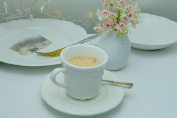 beautiful tender flat still life, cup of cappuccino on white background, delicate pink flowers, dishes with food, concept of of lunch in a restaurant, cafe, be happy