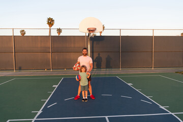 Obraz premium dad and kid boy play basketball. child hold sport ball. childhood and fatherhood.