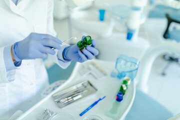 Fototapeta premium Close up of dentist's hands picking up dental equipment.