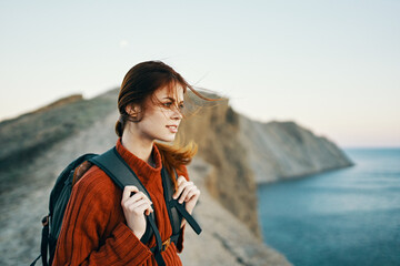 nature mountains fresh air and a young traveler with a backpack and a sweater are resting near the sea