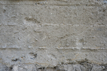 Obraz na płótnie Canvas Grey concrete wall with cracks and stones