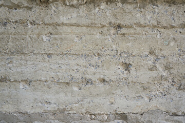 Concrete wall with cracks and stones