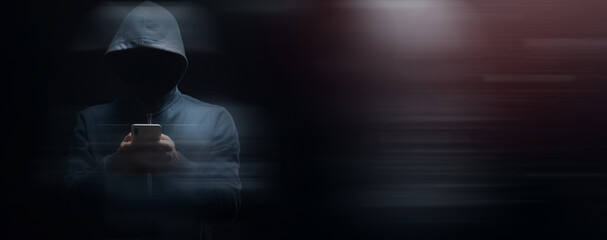 holds the phone on a dark background. hacker concept