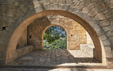 Arcadi monastery in Crete, Greece, stone arches in monastery lush green garden