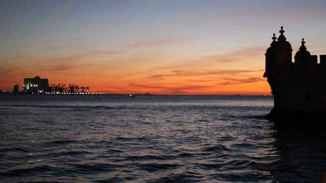 Cruise ship in distance sailing on the sunset towards Belem Tower in Lisbon, Portugal
