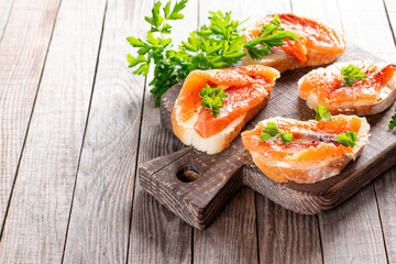 Mini salmon sandwiches on board. Copy space