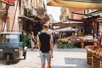 Poster picture from the back of a young tourist exploring a typical italian market in Palermo © NDStock