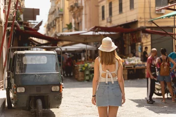 Poster picture from the back of a young tourist exploring a typical italian market in Palermo © NDStock