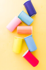 Colored bowl  orange ,yellow pink ,blue and green color flatlay, over a blue wallpaper type background, top view, flatlay