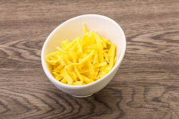 Shredded yellow cheese in the bowl