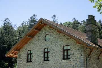 Fototapeta na wymiar Stone building with a gable roof. Historical stone house.