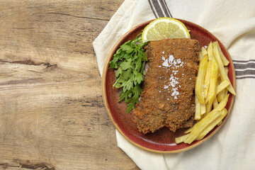Homemade traditional Milanese veal escalope with french fries
