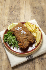 Homemade traditional Milanese veal escalope with french fries