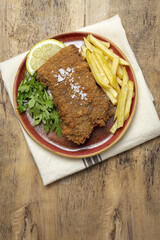 Homemade traditional Milanese veal escalope with french fries