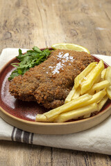 Homemade traditional Milanese veal escalope with french fries