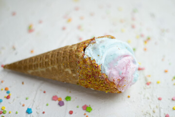 ice cream cone with sprinkles on a light background