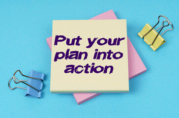 On the table are paper clips, note paper with text - Put your plan into action