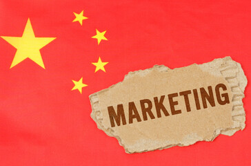 Against the background of the Chinese flag lies cardboard with the inscription - marketing