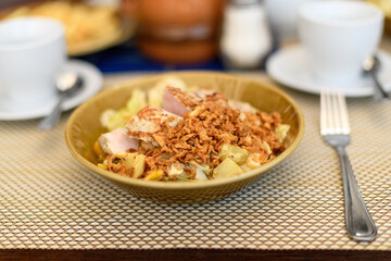 Plate salad fried onion chips on the table .