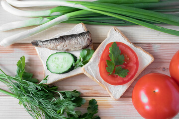 Two sandwiches with seafood, vegetables and herbs, on a wooden background, close up