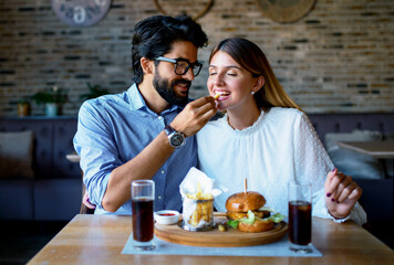 Young couple sitting in a cafe, having breakfast. Love, dating, food, lifestyle concept