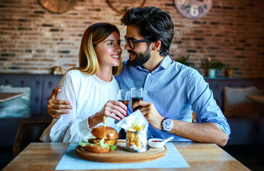 Young couple sitting in a cafe, having breakfast. Love, dating, food, lifestyle concept
