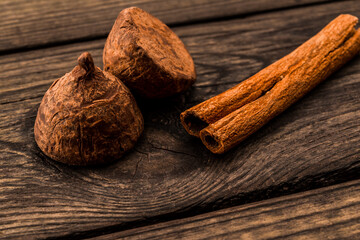 Cinnamon stick and chocolate truffles on an old wooden table. Close up view