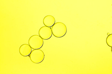 Oil drops in water, bubbles and circles on a yellow background