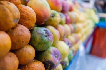 Close-up of a colorful fruit stand with tangerines and mangoes