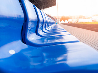 Empty stands in a stadium or sports field. The stands for the fans are blue. Without fans and fans