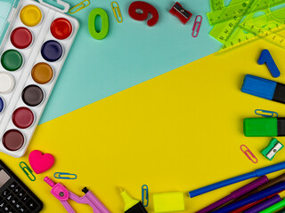 student's desk. Top view of the layout of school items. Rulers, paints, pencils and numbers on a yellow and blue background. Back to school
