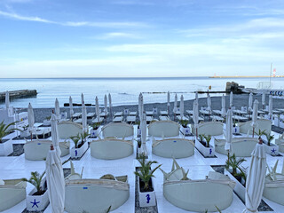 Sun beds and umbrellas on the first line of the sea. Hotel beach.