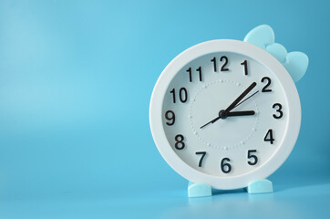 White watch with a bow on a blue background.
