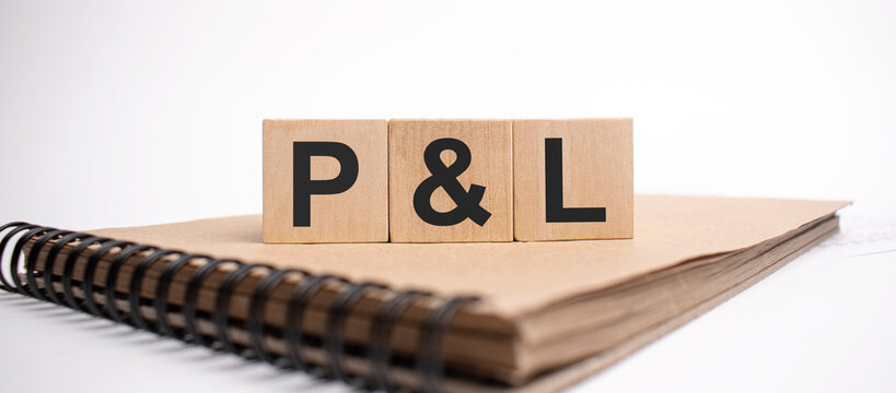 Text p and l on the wooden cubes and craft colored notepad on the white background