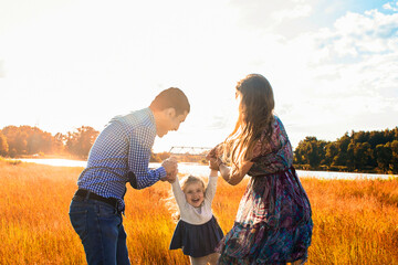 happy family at sunset, having fun with a child in nature