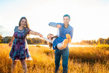 happy family at sunset, having fun with a child in nature