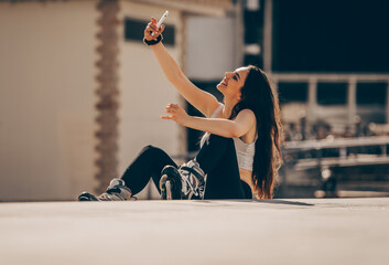 Urban girl with inline skates taking selfies