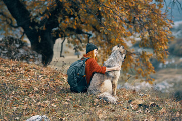 woman hiker with dog in the mountains admires nature travel