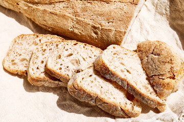 Sliced bread on linen towel. Top view of sourdough bread. Traditional leavened bread baking method. Healthy food concept
