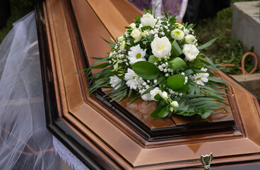 bouquet of white flowers on a coffin in the cemetery