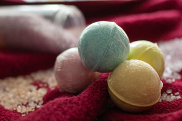 Bath salt and bombs on a burgundy terry towel. Spa accessories and products