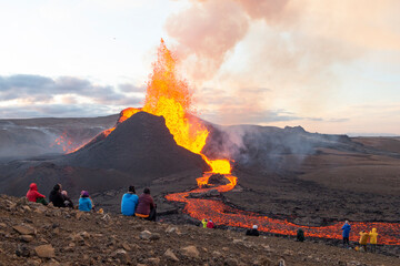 GELDINGADALIR, ICELAND - 11 MAY, 2021: A small volcanic eruption started at the Reykjanes peninsula. The event has attracted thousands of visitors who have braved a daring hike to the crater. - obrazy, fototapety, plakaty