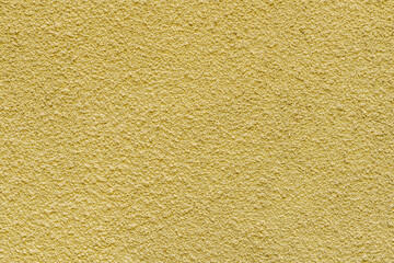 abstract background of an old embossed wall painted yellow close up