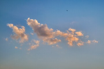 Summer evening sky in the picturesque clouds, lit by the rays of the setting sun.