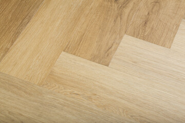 Laminate and parquet with herringbone background. Wooden floor with a chevron pattern in the living room of the designer interior.