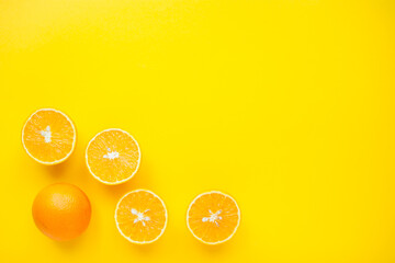 layout of bright orange oranges on a bright yellow background. High quality photo