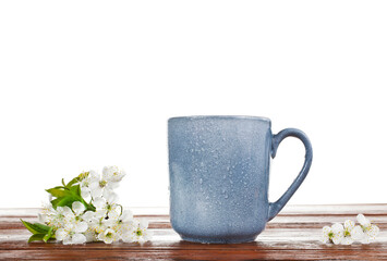 Blue ceramic cup with cherry blossoms isolated on a white background.