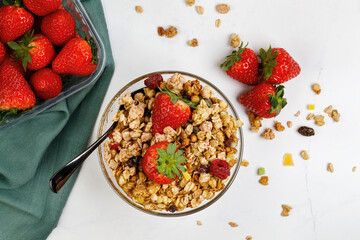 Muesli with strawberries and honey in a glass plate, isolated on a white background. Healthy breakfast.